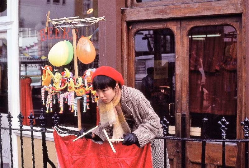 Ngườ phụ nữ biểu diễn múa rối dạo bên ngoài quán rượu Earl of Lonsdale ở phố Portobello, 1980. Ảnh: Glen Fairweather.