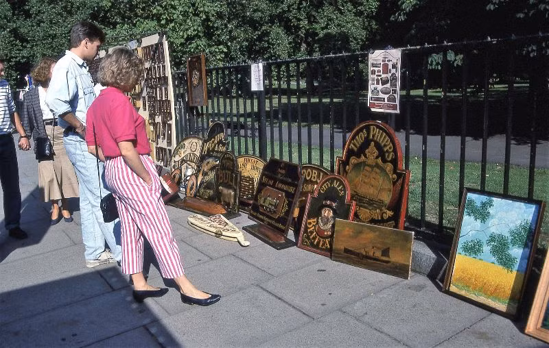 Quầy hàng tranh vỉa hè bên lối vào ga Green Park, gần vòng xoay Piccadilly Circus, 1989. Ảnh: Glen Fairweather.