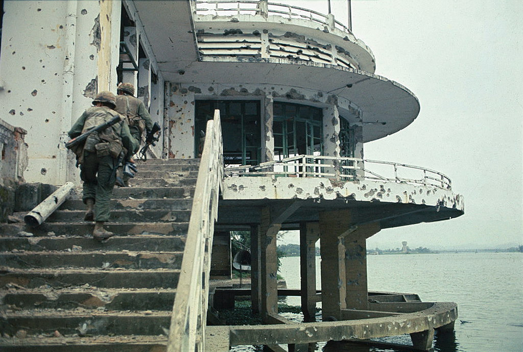 Lính Mỹ tiến vào khu nhà hàng nổi bên bờ sông Hương ở Huế ngày 5/2/1968. Ảnh: UPI.