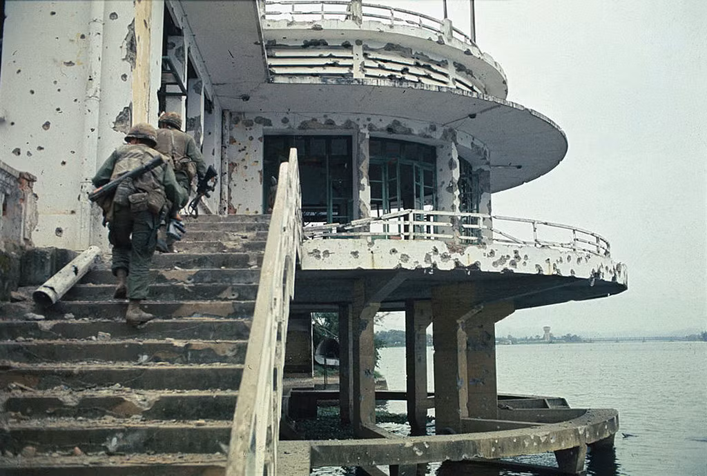 Lính Mỹ tiến vào khu nhà hàng nổi bên bờ sông Hương ở Huế ngày 5/2/1968. Ảnh: UPI.