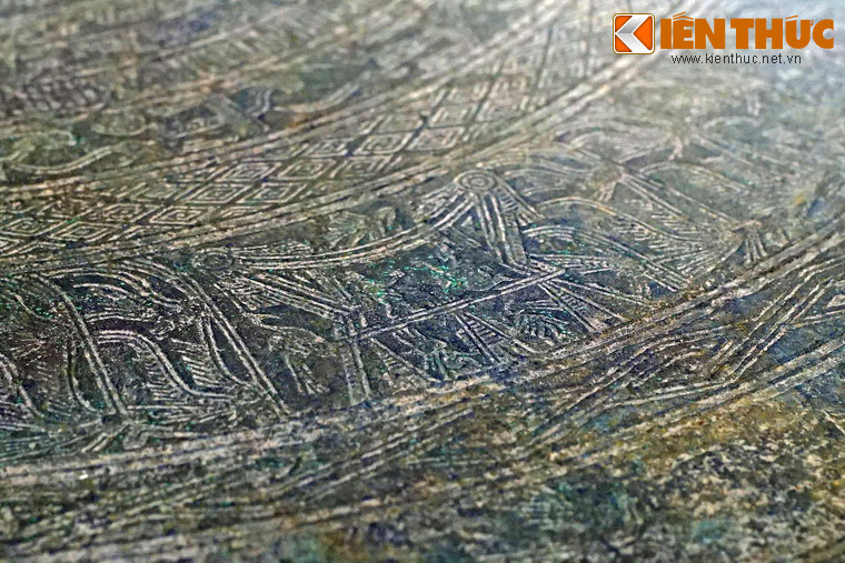 Cảnh sinh hoạt được thể hiện trên mặt trống qua hình tượng người hoá trang xen kẽ bốn ngôi nhà sàn mái cong, mái rủ.