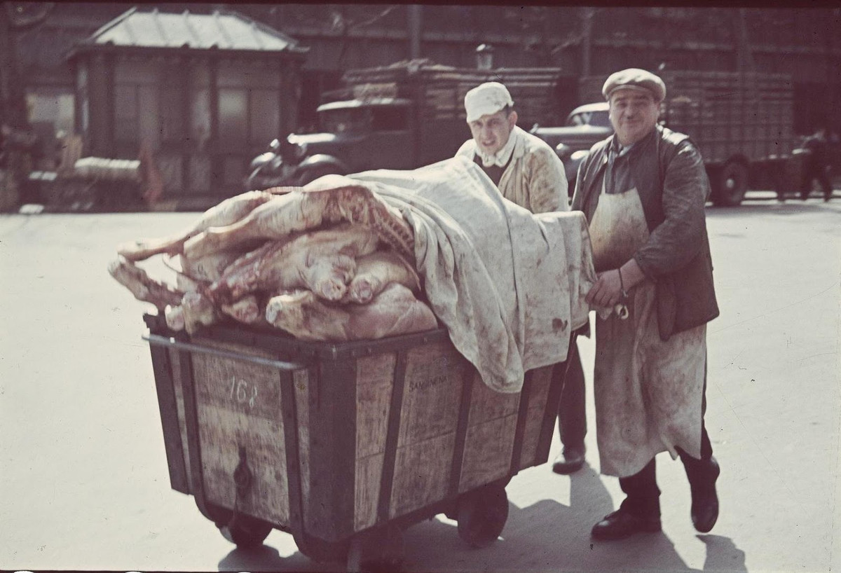 Hai người bán thịt đẩy chiếc xe chở thịt trên đường. Ảnh: André Zucca.