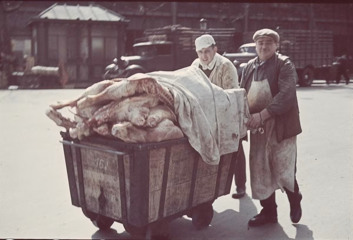 Hai người bán thịt đẩy chiếc xe chở thịt trên đường. Ảnh: André Zucca.