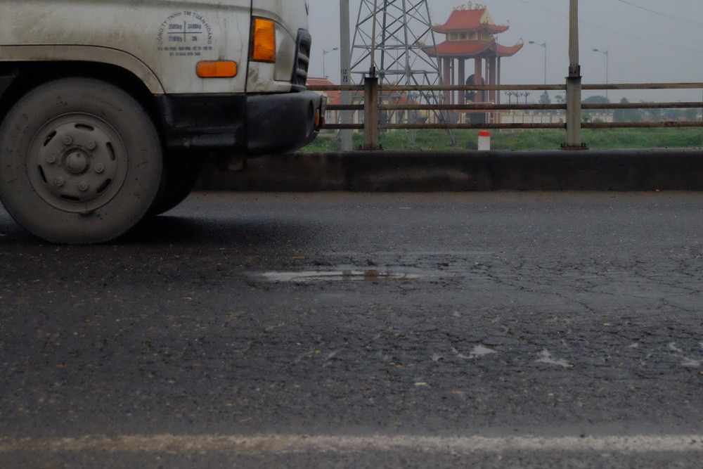 Nhiều ổ gà xuất hiện lồi lõm trên bề mặt của đường, gây khó khăn cho các phương tiện tham gia giao thông.