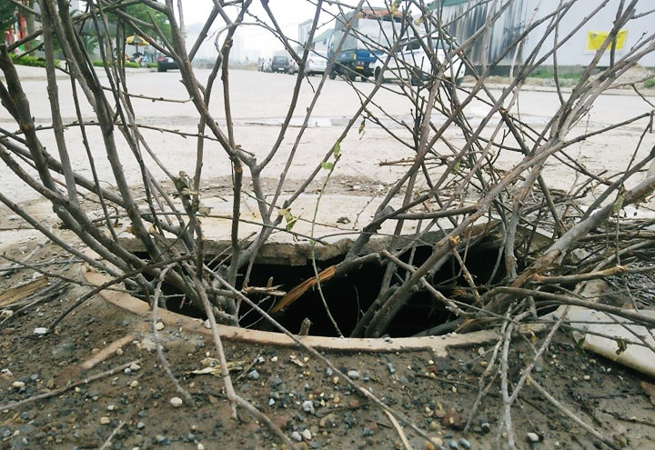 Không chỉ đang tồn tại đất cát, rác thải ở nhiều đoạn đã trải xong nhựa trên tuyến đường này hiện nắp cống thoát nước bị vỡ, mất nhiều chỗ. Người dân đành phải sử dụng những cành cây cắm vào để cảnh báo cho những người khác lưu thông qua đây biết được, tránh xảy ra tai nạn.