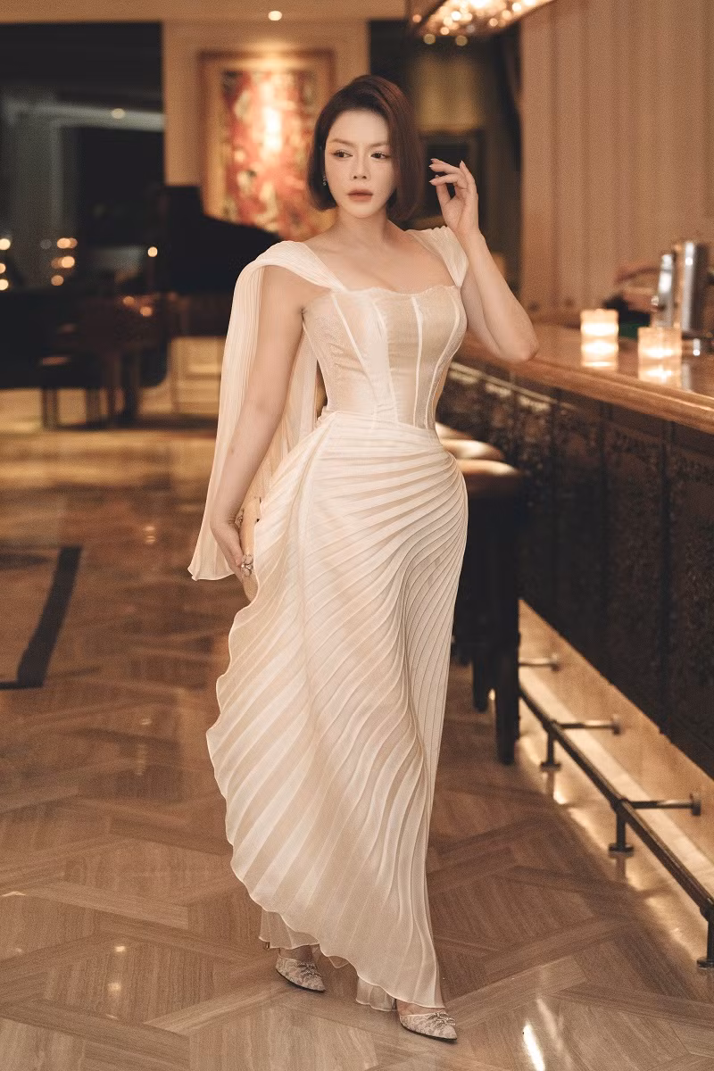 Diễn viên Kiều nữ và đại gia chọn chiếc váy được thực hiện cầu kỳ, với chi tiết chiết eo giúp tôn lên đường cong nóng bỏng. Phần chân váy được sử dụng kỹ thuật xếp ly, tạo hiệu ứng khi di chuyển.