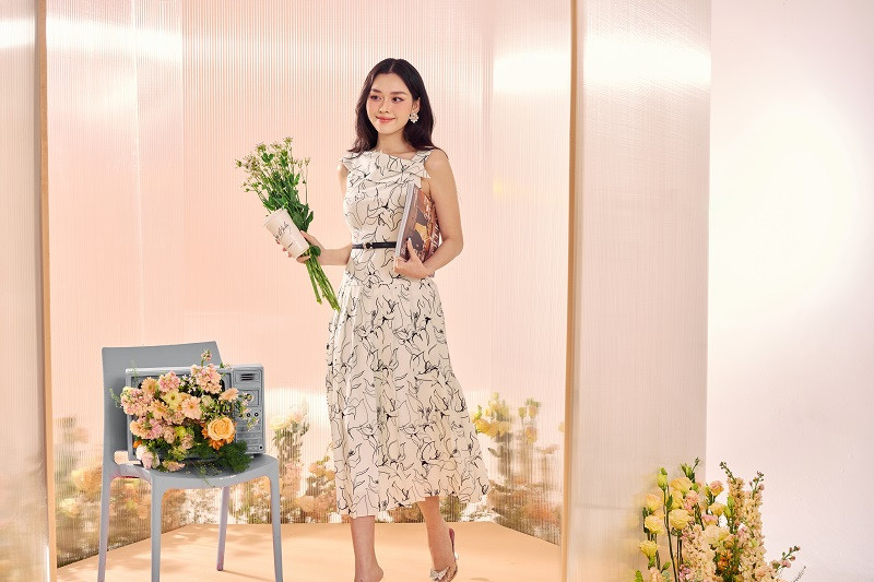 Đầm in họa tiết nét vẽ tay là một trong những item mang đến sự độc đáo, thu hút. Trong ảnh, Tường San diện chiếc đầm trắng thanh khiết với họa tiết in hoa nổi bật. Chi tiết bất đối xứng ở phần cổ tạo nên điểm nhấn của chiếc đầm.
