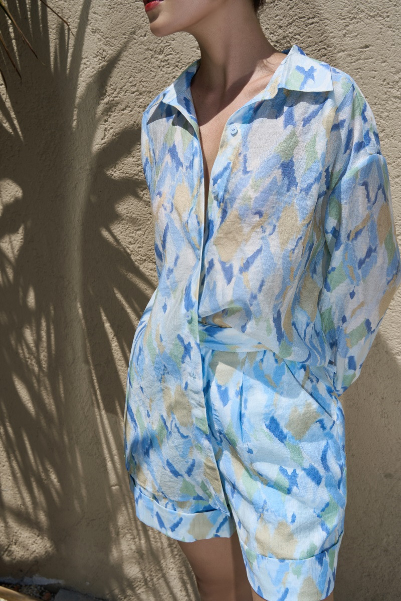 Áo sơ mi và quần short, một sự độc đáo và phá cách cho thời trang nữ vào mùa nắng nóng. Áo sơ mi giữ nguyên kiểu dáng truyền thống với cổ đức, tay dài. Bên cạnh thiết kế xẻ tà hai bên tạo sự cách điệu. Quần short dáng ngắn, cạp cao, tôn dáng, phù hợp cho các hoạt động ngoài trời.