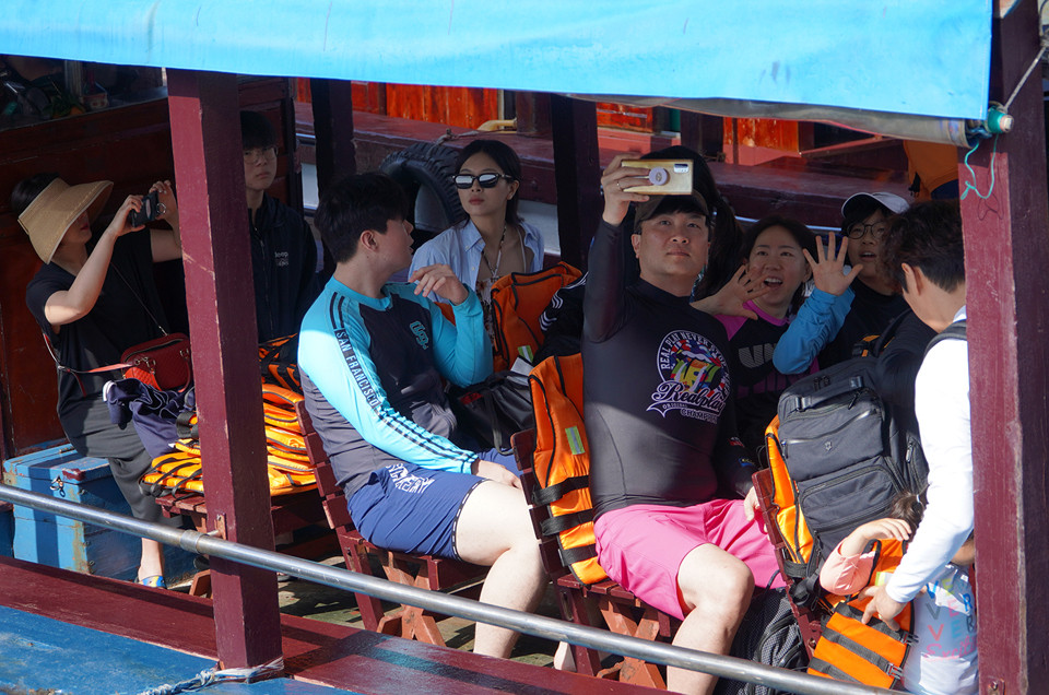 Một gia đình người Hàn Quốc chụp ảnh kỷ niệm khi lên tàu gỗ khám phá Vịnh Nha Trang.