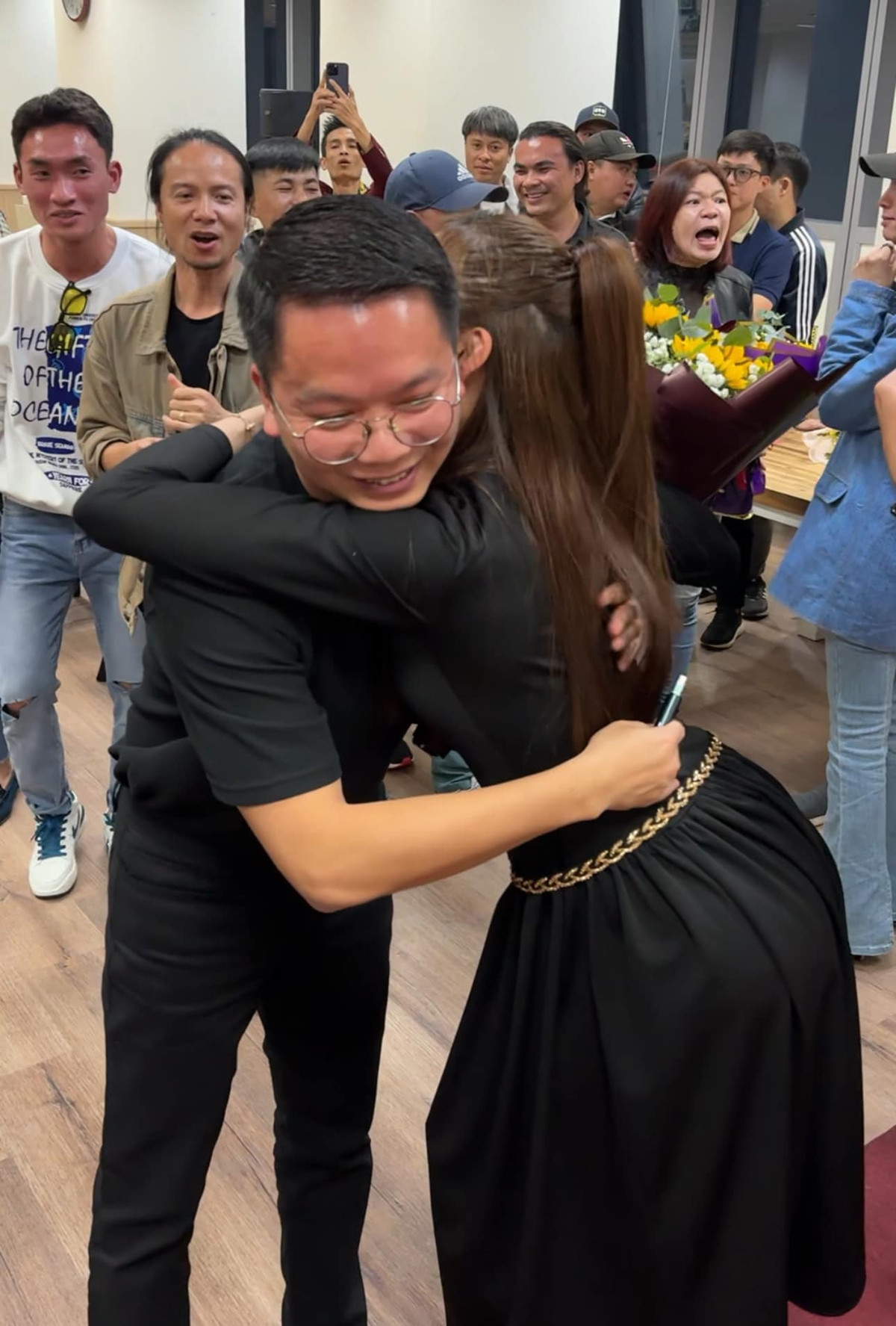 Thùy Anh ôm đạo diễn Bùi Tiến Huy trong tiệc mừng đóng máy bộ phim cùng ê-kíp.