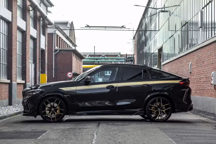 X6 Competition của Manhart trông hầm hố hơn nhờ thiết lập hệ thống treo mới của H&amp;R giúp hạ thấp chiều cao của xe đi 30 mm. Bộ la-zăng lớn 22 inch với lớp hoàn thiện màu đen sa tanh và các điểm nhấn bằng vàng lấp đầy các hốc bánh xe.