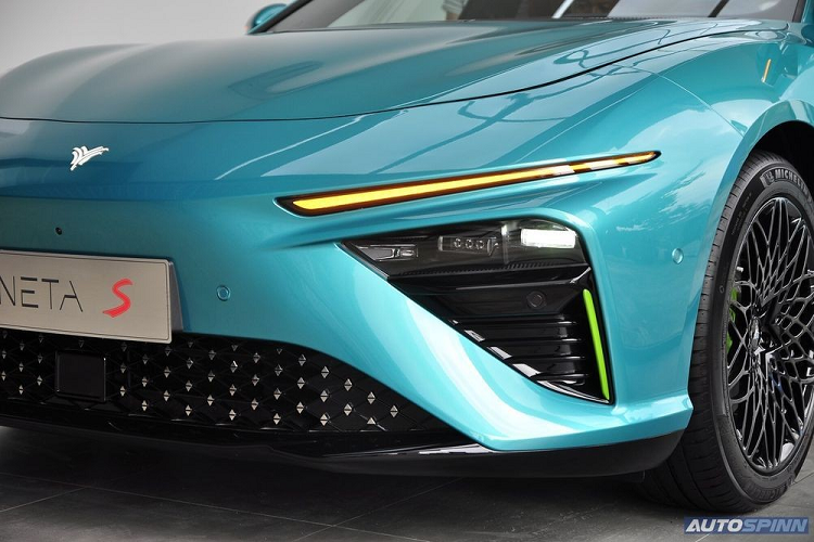 Tiếp đến là logo phát sáng của thương hiệu Neta, khe gió giả màu đen ở hai góc cản trước và hốc gió trung tâm hình ngũ giác khá rộng, đi kèm lưới mắt cáo trang trí bằng những chi tiết mạ crôm.