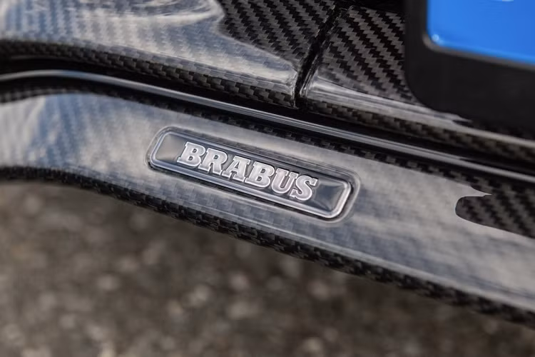 Bề mặt bệ tỳ tay và bảng điều khiển trung tâm của Brabus 600 Masterpiece cũng được ốp sợi carbon và logo Brabus được in trên lưng ghế.