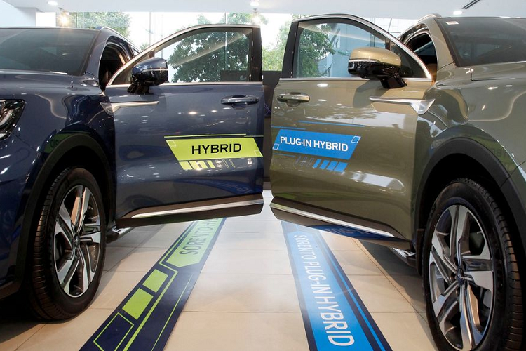 Khác với các mẫu xe Hybrid tự sạc, KIA Sorento PHEV 2023 tại Việt Nam được trang bị tính năng sạc ngoài với nguồn điện dân dụng (nhà/cơ quan) thông qua bộ sạc xe điện AC và bộ điều khiển sạc OBC (bộ chuyển đổi nguồn AC sang DC) nhằm nạp đầy năng lượng cho pin Lithium-ion. Người lái cũng có thể tùy chọn chế độ thuần điện EV/HEV bằng nút chuyển ở bảng điều khiển trung tâm.