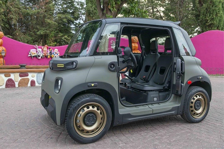 Một điểm nhấn đáng chú ý nữa của mẫu ô tô điện nhỏ xinh này chính là màu sơn ngoại thất xanh Khaki. Trong khi đó, hốc bánh, cản trước/sau và khu vực bên dưới cửa đều có nẹp bằng nhựa màu đen. Bộ vành sơn màu đồng khá nổi bật trên nền sơn màu xanh trầm.