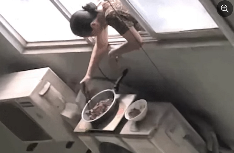 Nguoi phu nu tho dau ra cua so, nau an tren cuc nong dieu hoa cao tang