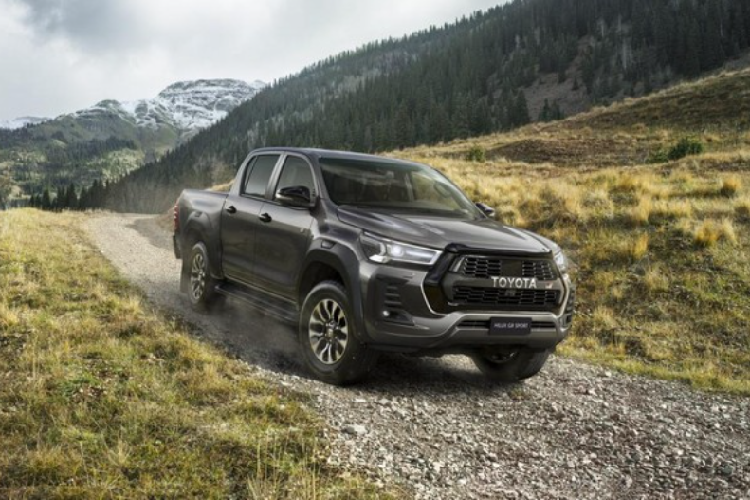 Bên trong xe, hãng Toyota trang bị hai ghế thể thao mang thương hiệu GR Sport, bọc da phối da lộn màu đen và đi kèm chỉ đỏ. Trong khi đó, logo "GR" xuất hiện khắp nơi, ở thảm sàn, nút bấm khởi động máy và màn hình thông tin giải trí lúc khởi động. Ngoài ra, cũng không thể không kể đến những chi tiết ốp giả sợi carbon, bộ bàn đạp bằng nhôm, đường màu đỏ kéo dài trên mặt táp-lô và đèn viền màu xanh dương ở mặt cửa của Toyota Hilux GR Sport 2022. Tất cả mang đến cảm giác mới mẻ và thể thao hơn cho mẫu xe bán tải này.
