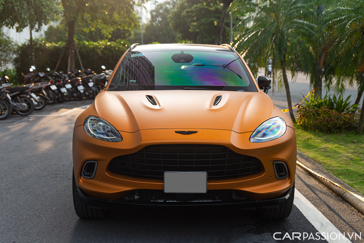 Aston Martin DBX trong bài sở hữu lớp sơn màu vàng cam nhám có tên Satin Golden Saffron. Màu sơn này nằm trong mục cá nhân hoá của bộ phận Q của Aston Martin. Đầu xe sỡ hữu lưới tản nhiệt ‘DB’ cỡ lớn đặc trưng. Cụm đèn chiếu sáng LED hình oval đơn giản, hệ thống đèn định vị ban ngày của xe được đặt bao quanh một hốc gió.