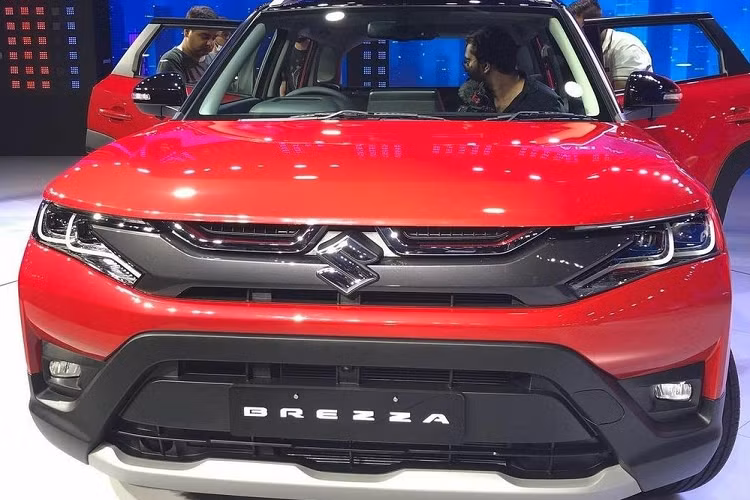 Đúng như những hình ảnh rò rỉ từ trước đó, Suzuki Brezza 2022 cho đô thị được áp dụng phong cách thiết kế mới. Theo đó, mẫu SUV hạng A này được trang bị nắp ca-pô hình vỏ sò phẳng hơn, hệ thống đèn pha với 2 bóng LED vuông vức, bao quanh bằng dải đèn LED định vị ban ngày và đèn sương mù trước mới. Cụm đèn pha này nối liền với nẹp dày dặn sơn màu xám nòng súng, nằm ngay bên dưới lưới tản nhiệt. 