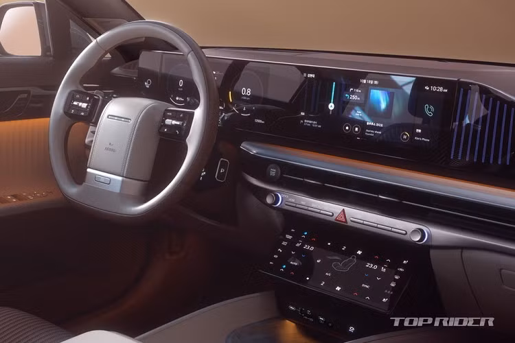 Hyundai Grandeur 2023 không hề có cụm điều khiển trung tâm như thiết kế ôtô truyền thống. Thay vào đó, hãng Hyundai chỉ trang bị một màn hình cảm ứng khá lớn để người dùng chỉnh điều hòa. Bên dưới màn hình này là các cổng USB và ngăn chứa đồ có nắp che.