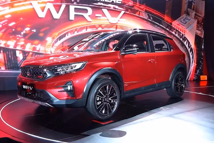 Xe sẽ dùng đèn pha Halogen ở bản tiêu chuẩn và đèn pha LED toàn phần, tích hợp dải đèn LED định vị ban ngày cũng như đèn LED báo rẽ tuần tự ở 2 bản RS. Tính năng đèn pha tự động sẽ có ở bản RS Honda Sensing cao cấp nhất. Dù ở bản nào, WR-V 2023 cũng được trang bị hốc gió trung tâm cỡ lớn với mắt lưới hình tổ ong, tấm ốp gầm giả màu bạc dưới cản trước và đèn sương mù nằm trong hốc hình tam giác ở hai góc đầu xe.