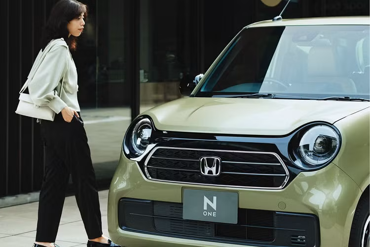 Mẫu xe kei car Honda N-One Style + Urban 2023 được phân biệt với bản thường bằng những chi tiết mạ crôm trên lưới tản nhiệt hình lục giác. Bao quanh lưới tản nhiệt này và 2 cụm đèn pha tròn trịa là tấm ốp màu đen bóng. Ngoài ra, Honda N-One Style + Urban 2023 còn có những chi tiết màu đen bóng khác như ốp gương ngoại thất, tay nắm cửa, nẹp trên cửa và vành la-zăng. Thêm vào đó là ốp màu đen với viền mạ crôm trên cửa cốp sau của xe.