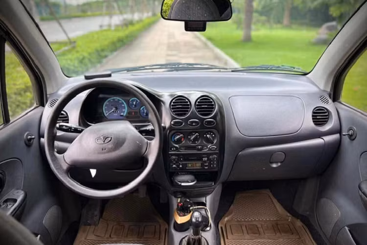 Bước vào bên trong, nội thất của chiếc Daewoo Matiz còn làm người xem kinh ngạc hơn. Vô lăng 2 chấu cơ bản đi cùng bộ ghế nỉ như mới xuất xưởng. Tiện ích trên xe được giữ nguyên với hệ thống điều hoà 1 vùng đi kèm radio và CD.