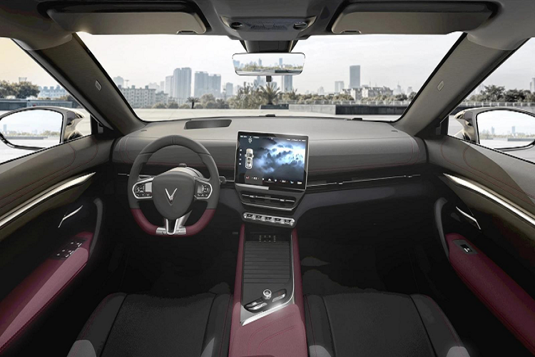 Hai bên hông xe VinFast VF7 có thiết kế khá ấn tượng với đường gân nổi kết hợp cùng các vùng khoét sâu, tạo cho xe vẻ mạnh mẽ và cứng cáp, nắm cửa được thiết kế chìm vừa giúp tăng tính khí động học, vừa mang đến sự liền mạch và gãy gọn. Ngay bên dưới cột a ở phần đầu xe là vị trí cổng sạc pin cho xe. Bước lùi về phía sau, phong cách thiết kế dải đèn LED dải ở đầu xe tiếp tục được áp dụng ở đèn phanh. Phần đèn phanh tích hợp xi-nhan dạng LED được bố trí hai bên logo chữ V, kéo dài sang đến hông xe. Bên dưới là hai hốc bố trí khe thoát gió. Vị trí bắt biển số phía sau được bố trí cao phía trên cản sốc sau trên nền đen khá nổi bật.