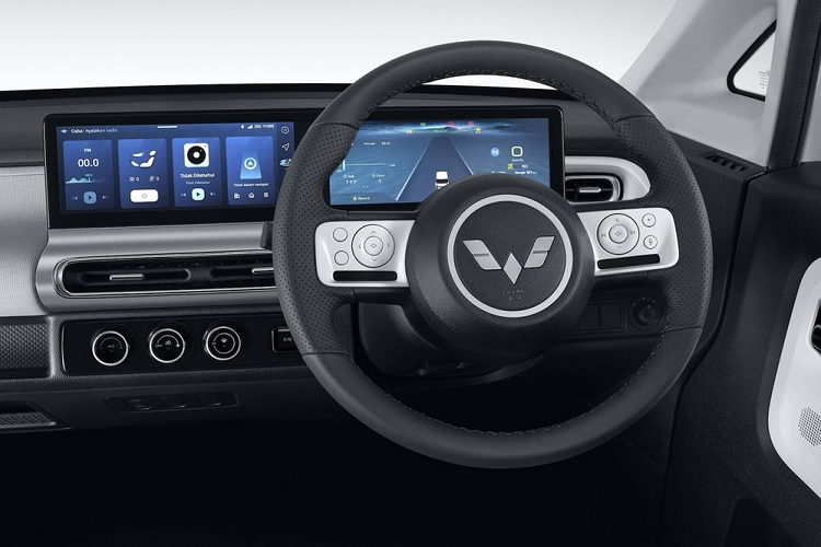 Ngoài ra, Wuling Air ev 2022 còn có vô lăng 2 chấu tích hợp các phím chức năng như chỉnh âm lượng, cài đặt danh mục của màn hình và ra lệnh bằng giọng nói. Nằm giữa 2 ghế trước là núm xoay chuyển số, phanh tay điện tử và tính năng tự động giữ phanh tạm thời.
