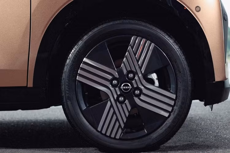 Bên ngoài, Nissan Sakura sở hữu thiết kế hatchback và trông khá giống với đàn anh Ariya, đặc biệt là phần đầu xe. Tại đây, chúng ta sẽ tìm thấy lưới tản nhiệt đóng kín, sơn màu đen bóng và được bao quanh bằng dải đèn LED định vị ban ngày hình boomerang. Bên cạnh đó là cụm đèn pha LED khá hẹp, khe gió giả hình tam giác nằm dọc ở hai góc đầu xe và hốc gió trung tâm hình thang cỡ lớn.