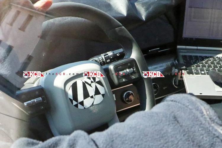 Bên trong cabin, Hyundai Kona 2023 sẽ có thiết kế khác hẳn với mẫu xe hiện hành. Theo hình ảnh trên mẫu xe thử nghiệm có thể thấy rằng Kona thế hệ mới sẽ có những đường nét “vay mượn” từ mẫu SUV điện Ioniq 5. Cụ thể là bảng điều khiển hiện đại hơn với bảng đồng hồ kỹ thuật số và màn hình thông tin giải trí liền khối, vô lăng đa chức năng bốn chấu mới, khu vực ốp cửa cũng có thêm các họa tiết khác màu tạo điểm nhấn.