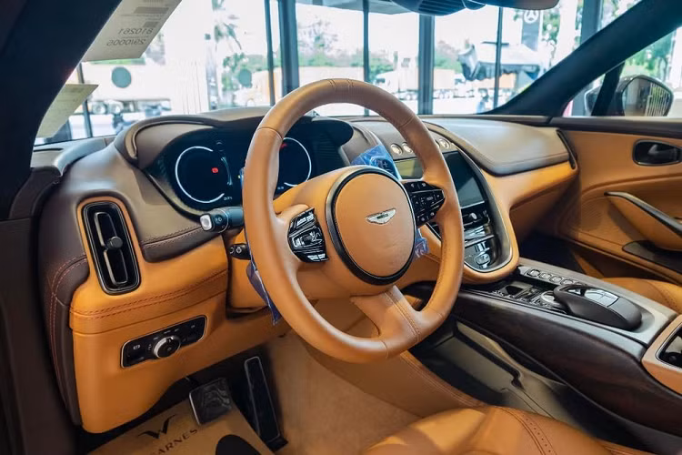 Logo cánh chim của xe được sơn bạc, không phải màu đen như tùy chọn trên chiếc Aston Martin DBX màu Satin Golden Saffron độc nhất Việt Nam.