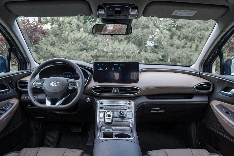 Bên trong Hyundai SantaFe 2023 phiên bản 6 chỗ là không gian nội thất bọc da phối 2 màu với 3 hàng ghế. Hàng ghế trước có tính năng sưởi ấm và làm mát. Ở giữa là 2 ghế thương gia, tách rời với nhau và đi kèm bệ tì tay riêng. 2 ghế này có thể chỉnh bằng tay và có tính năng sưởi. Trong khi đó, hàng ghế cuối cùng có thể gập chỉnh điện và được trang bị cửa gió điều hòa.