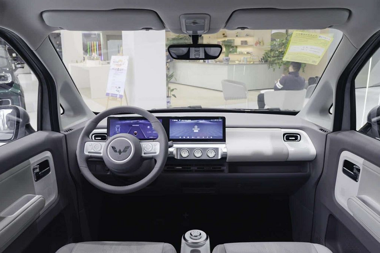 Bên sườn, mẫu xe này chỉ có 2 cửa đồng thời được trang bị bộ vành có đường kính 12 inch, nằm trong lốp 145/70 R12 và đi kèm chụp la-zăng màu đen - trắng. Bước vào trong cabin, Wuling Air ev 2022 có nội thất thiết kế tối giản, bọc da tổng hợp hai tông màu.