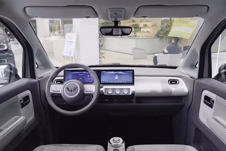 Bên sườn, mẫu xe này chỉ có 2 cửa đồng thời được trang bị bộ vành có đường kính 12 inch, nằm trong lốp 145/70 R12 và đi kèm chụp la-zăng màu đen - trắng. Bước vào trong cabin, Wuling Air ev 2022 có nội thất thiết kế tối giản, bọc da tổng hợp hai tông màu.