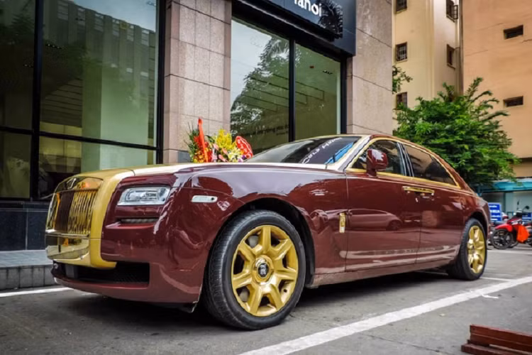 Ngoài màu sơn đỏ, chiếc xe siêu sang Rolls-Royce Ghost này còn có nhiều chi tiết sơn vàng đối lập và ấn tượng nhất còn được xưởng độ danh tiếng Real Gold Group tại Đức đảm nhận mạ vàng 24k một số chi tiết ở ngoại thất như lưới tản nhiệt, tay nắm cửa, logo Rolls-Royce bên hông xe, các thanh viền inox cũng được mạ vàng 24k và viền đèn hậu.