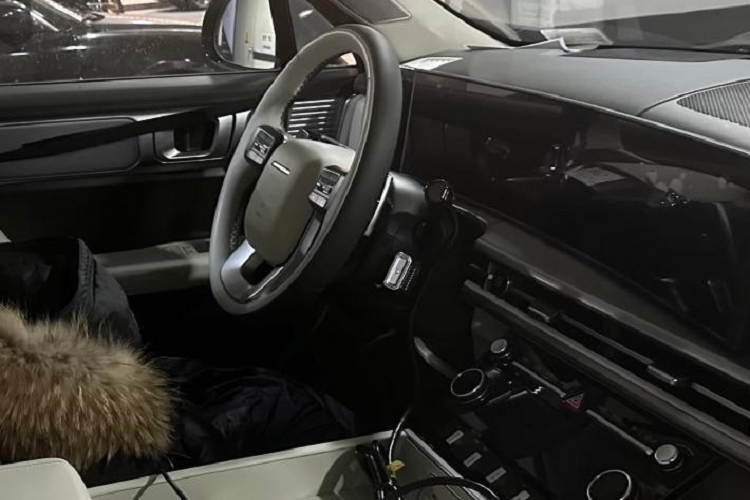Đằng sau vô lăng này là màn hình cong cỡ lớn, kết hợp giữa bảng đồng hồ kỹ thuật số và màn hình cảm ứng trung tâm. Bên dưới là cửa gió điều hòa nằm kéo dài trên mặt táp-lô khiến khu vực nội thất của xe như rộng hơn. Tiếp đến là màn hình nhỏ và các núm xoay để chỉnh điều hòa cũng như âm lượng.