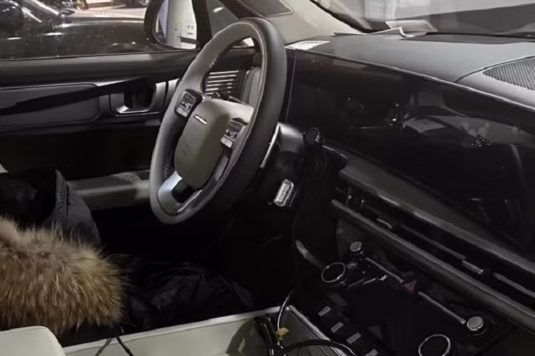 Đằng sau vô lăng này là màn hình cong cỡ lớn, kết hợp giữa bảng đồng hồ kỹ thuật số và màn hình cảm ứng trung tâm. Bên dưới là cửa gió điều hòa nằm kéo dài trên mặt táp-lô khiến khu vực nội thất của xe như rộng hơn. Tiếp đến là màn hình nhỏ và các núm xoay để chỉnh điều hòa cũng như âm lượng.