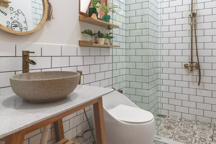 Phòng vệ sinh khép kín bên trong phòng master tiện nghi. Điểm nhấn là sàn gạch bông bắt mắt. Bồn rửa mặt hình tròn lắp nổi trên mặt đá. Phía dưới là bệ bằng gỗ mộc mạc. Cây xanh tiếp tục phát huy tác dụng, trang trí cho phòng thêm đẹp và xanh mát.