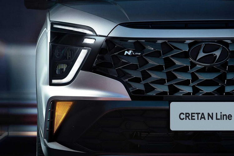 So với bản thường, Hyundai Creta N Line 2022 trông nổi bật hơn nhờ thiết kế đầu xe mới với lưới tản nhiệt rộng hơn, đi kèm mắt lưới màu tối và logo "N Line". Thêm vào đó là cản trước hầm hố hơn, tích hợp hốc gió trung tâm hình thang màu đen.