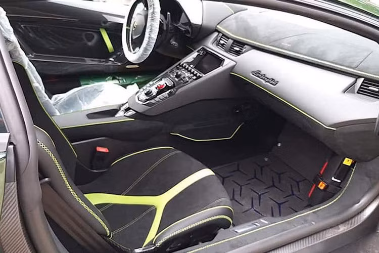 Ở bên trong, Aventador SVJ sở hữu nội thất màu đen chủ đạo, điểm xuyết các chi tiết màu xanh bắt mắt trùng với ngoại thất và rất nhiều bề mặt sợi carbon xuất hiện khắp cabin. Xe được trang bị option ghế đua thể thao...