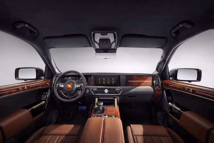 Nằm bên dưới màn hình trung tâm của xe là cửa gió trung tâm và 2 núm xoay chỉnh điều hòa. Ở giữa 2 cửa gió này có đồng hồ cơ để báo giờ giấc. Chưa hết, Hồng Kỳ LS7 còn có 2 cột màu vàng kim ở cụm điều khiển trung tâm và cần số ngắn, bọc da sang trọng.