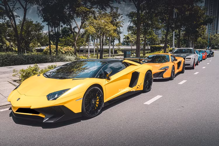 Buổi họp mặt quy tụ một loạt cả dàn siêu xe trăm tỷ đồng đến từ các thương hiệu đình đám như: Lamborghini, McLaren, Porsche,… Dẫn đầu là chiếc Lamborghini Aventador SV Roadster hàng hiếm với lớp áo ngoại thất màu vàng trẻ trung,
