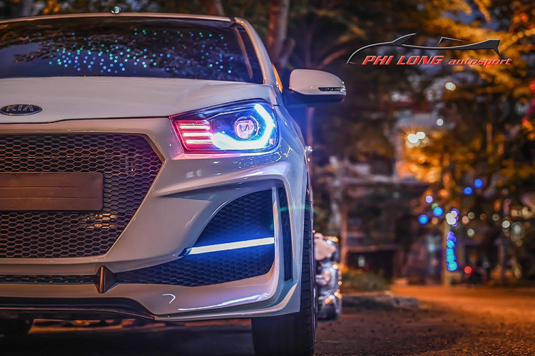 Cách tạo hình cho phần mặt tiền xe Kia Soluto đã giúp mẫu sedan hạng B có thêm nhiều nét cắt cùng với đó là lưới tản nhiệt và hốc gió cỡ lớn hầm hố. Vốn được trang bị hệ thống đèn pha halogen rẻ tiền nên trong dự án độ này, chủ nhân xe Kia Soluto đã nâng cấp toàn bộ đôi mắt của xe lên LED và thay luôn dải dèn LED chiếu sáng của xe dạng 3 tầng màu đỏ.