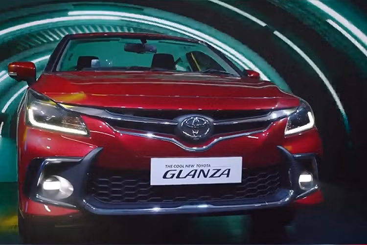 Bước sang phiên bản mới, mẫu xe hatchback Toyota Glanza thay đổi đáng kể trong thiết kế ngoại thất và trang bị nội thất. Trong đó, thiết kế đầu xe của Toyota Glanza 2022 khác biệt hoàn toàn so với Suzuki Baleno mới. Tại đây, mẫu hatchback giá rẻ này được trang bị lưới tản nhiệt theo phong cách của những mẫu xe Toyota đời cũ. Lưới tản nhiệt có 2 nẹp mạ crôm, nối liền với logo Toyota ở giữa.