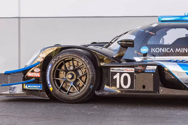 Được hoàn thiện với màu sơn #10 Konica Minolta màu đen, bạc và xanh dương trên thân xe liền khối bằng sợi carbon do ORECA chế tạo, chiếc xe đua này đã có một sự nghiệp đua xe thể thao thành công.