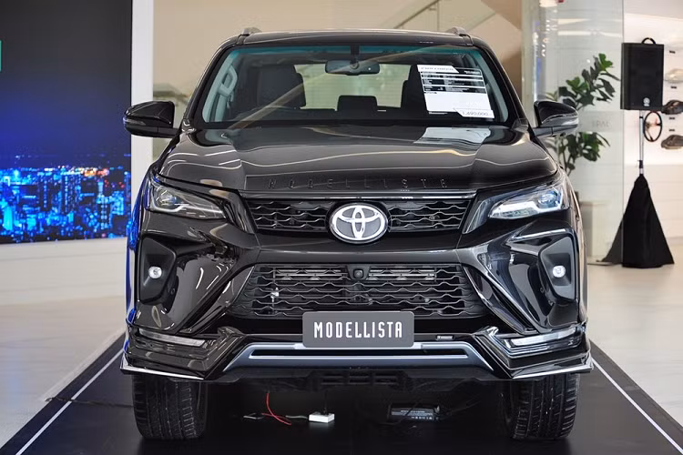Nhờ gói phụ kiện Modellista - đối tác ruột của hãng Toyota, mẫu SUV hạng D này có thêm ốp cản trước và ốp cản sau mới. Thêm vào đó là tem chữ nổi "Modellista" được sơn màu đen bóng nằm trên nắp ca-pô và nẹp mạ crôm hình chữ "Y" mới ở hai góc cản trước.