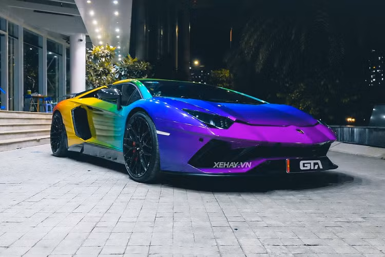 Phần cản trước của chiếc Lamborghini Aventador Roadster hàng hiếm này đã được nâng cấp lên bản Aventador S, tiếp đến là màu sơn ngoại thất 7 sắc cầu vồng vô cùng nổi bật. Tính đến thời điểm hiện tại, thì đây là chiếc Lamborghini Aventador thứ 2 tại Việt Nam mang màu sơn ngoại thất sặc sỡ này.
