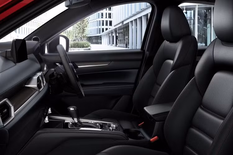 Bên trong Mazda CX-5 2022 tại Indonesia là không gian nội thất 5 chỗ bọc da như trước. Riêng bản Kuro sẽ đi kèm nội thất màu đen với chỉ khâu màu đỏ ở vô lăng, cần số, bệ tì tay trên cửa và cụm điều khiển trung tâm.