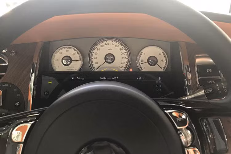 Khoang nội thất của chiếc Roll-Royce Dawn bọc da cao cấp màu trắng sữa, kết hợp với nhiều chi tiết ốp gỗ, toát lên vẻ sang trọng. Đồng hồ kim gắn logo Dawn đặt nổi bật tại trung tâm bảng taplo.